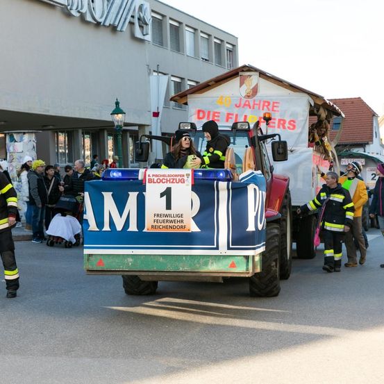 Eine Feuerwehr-Parade mit Freiwilligen vor einer Menge, die die Nummer 1 und die Worte AMR auf dem Heck anzeigt.