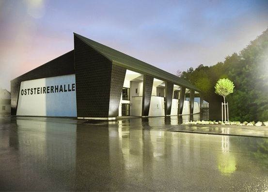 Das Bild zeigt ein architektonisches Gebäude namens Oststeirerhalle. Es ist von Grün umgeben und hat ein modernes Design.