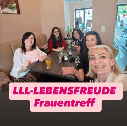 Eine Gruppe von Frauen sitzt mit Getränken an einem Tisch und lächelt für ein Foto. Die Worte 'LLL-Lebensfreude Frauentreff' sind auf dem Bild geschrieben.