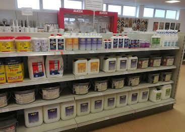 Ein Ladenregal gefüllt mit verschiedenen weißen und gelben Behältern, einige mit rotem Text beschriftet. Viele der Behälter tragen den Schriftzug 'SATA'.