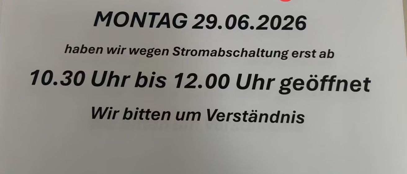 Ein Schild auf weißem Hintergrund mit rotem und schwarzem Text besagt: 'Unser Geschäft in Vordernberg. Montag, 29.06.2026, wegen Stromausfall erst ab 15:30 Uhr bis 12:00 Uhr geöffnet. Wir bitten um Verständnis.'