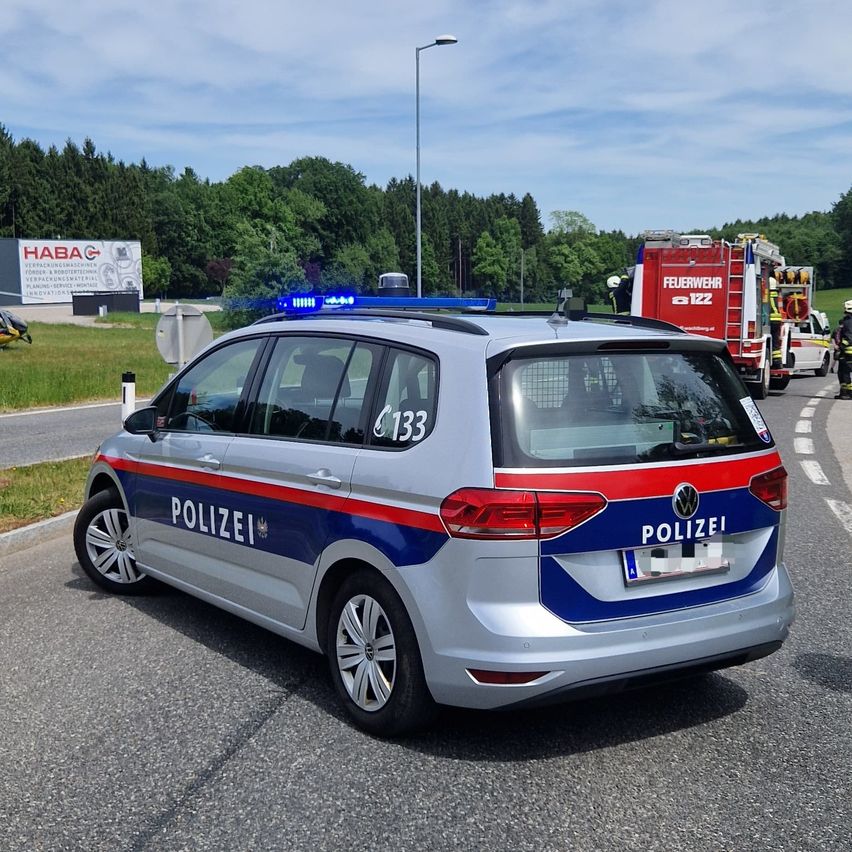 A police car is parked on the side of the road. Behind it, a fire truck is responding to an incident with emergency lights on.