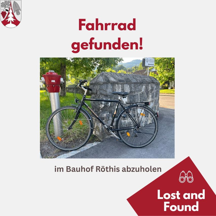 Ein schwarzes Fahrrad steht am Straßenrand neben einem Hydranten und einer Steinmauer. Eine rote Nachricht lautet 'Fahrrad gefunden!' und lädt dazu ein, es im Bauhof Röthis abzuholen.