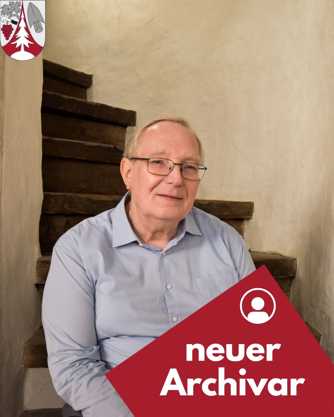 Ein älterer Mann in einem hellblauen Hemd mit Brille steht auf einer hölzernen Treppe mit den Worten 'neuer Audio' in Weiß auf einem roten Hintergrund.