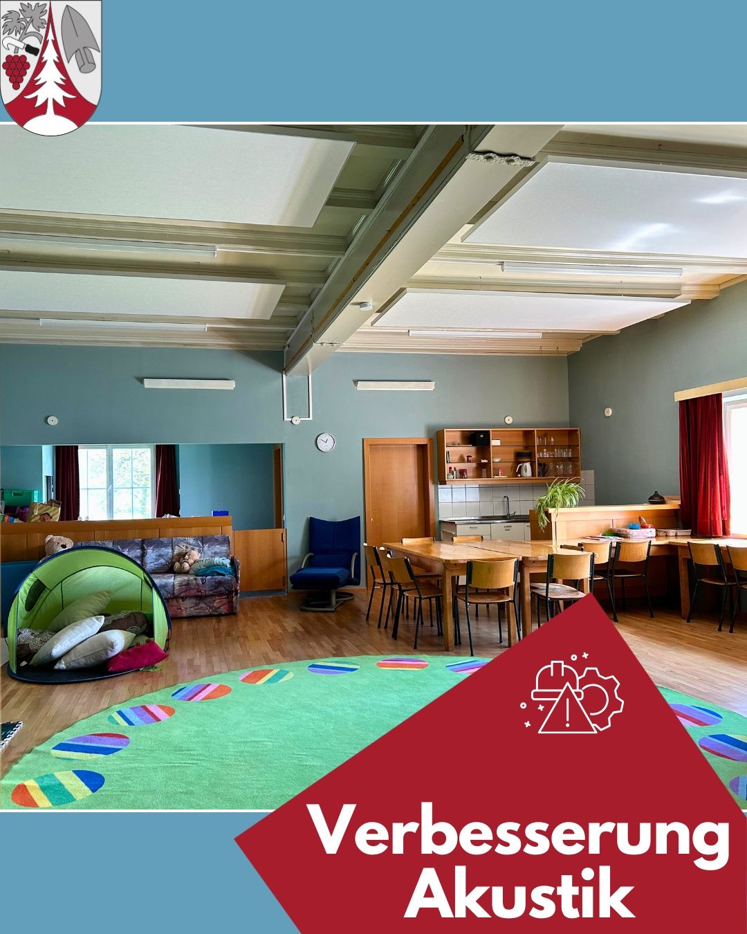 Ein geräumiger Raum mit einem grünen Teppich, einem Esstisch und einem Spielzelt. Ein Logo für Verbesserung befindet sich auf der rechten Seite.