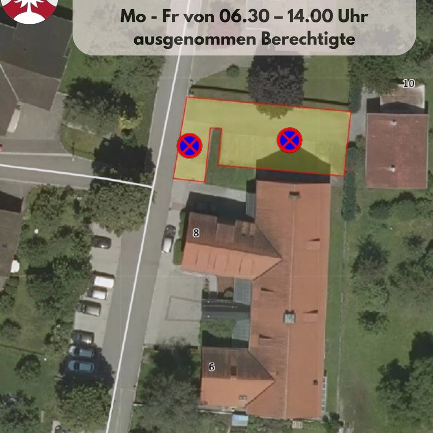 Luftaufnahme eines Wohngebiets mit einem Haus, einer Straße und Parkplätzen. Das Haus hat einen markierten Bereich und zwei rote Kreuze.