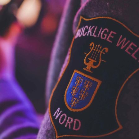 Bild enthält, Badge, Logo, Symbol, Person