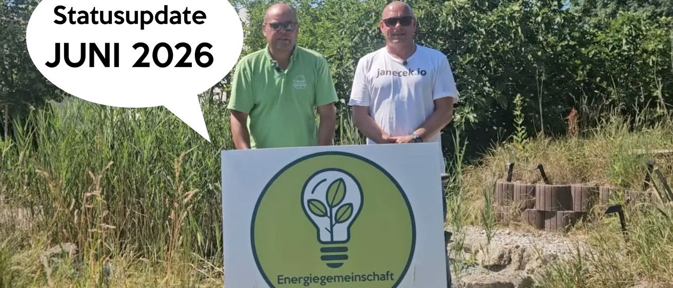 Zwei Männer stehen neben einem Schild mit einer Bild einer Glühbirne. Einer trägt ein grünes Shirt, der andere ein weißes Shirt mit Text. Eine Sprechblase sagt 'Update 2026.'