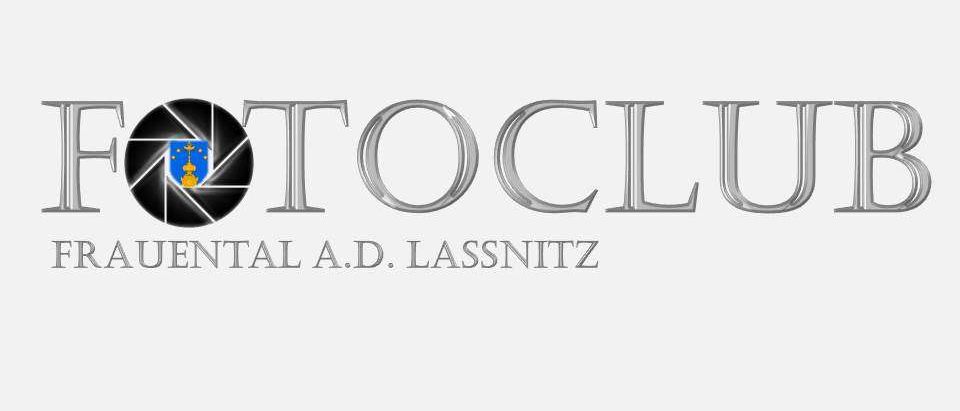 Das Bild zeigt das Logo des Fotoclubs A.D. Lassnitz. Es enthält ein Kamera-Objektiv-Symbol mit einem kreisförmigen Design, den Text 'FOTOCLUB' in großen, stilisierten silbernen Buchstaben und den Namen 'A.D. LASSNITZ' darunter.