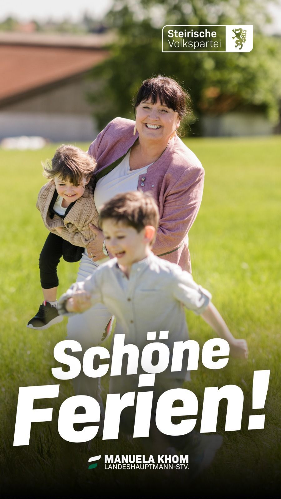 A smiling woman holds a young boy while another child runs towards them on a grassy field. The woman wears a pink cardigan and the children are dressed in casual clothes. The image has a cheerful and joyful atmosphere.