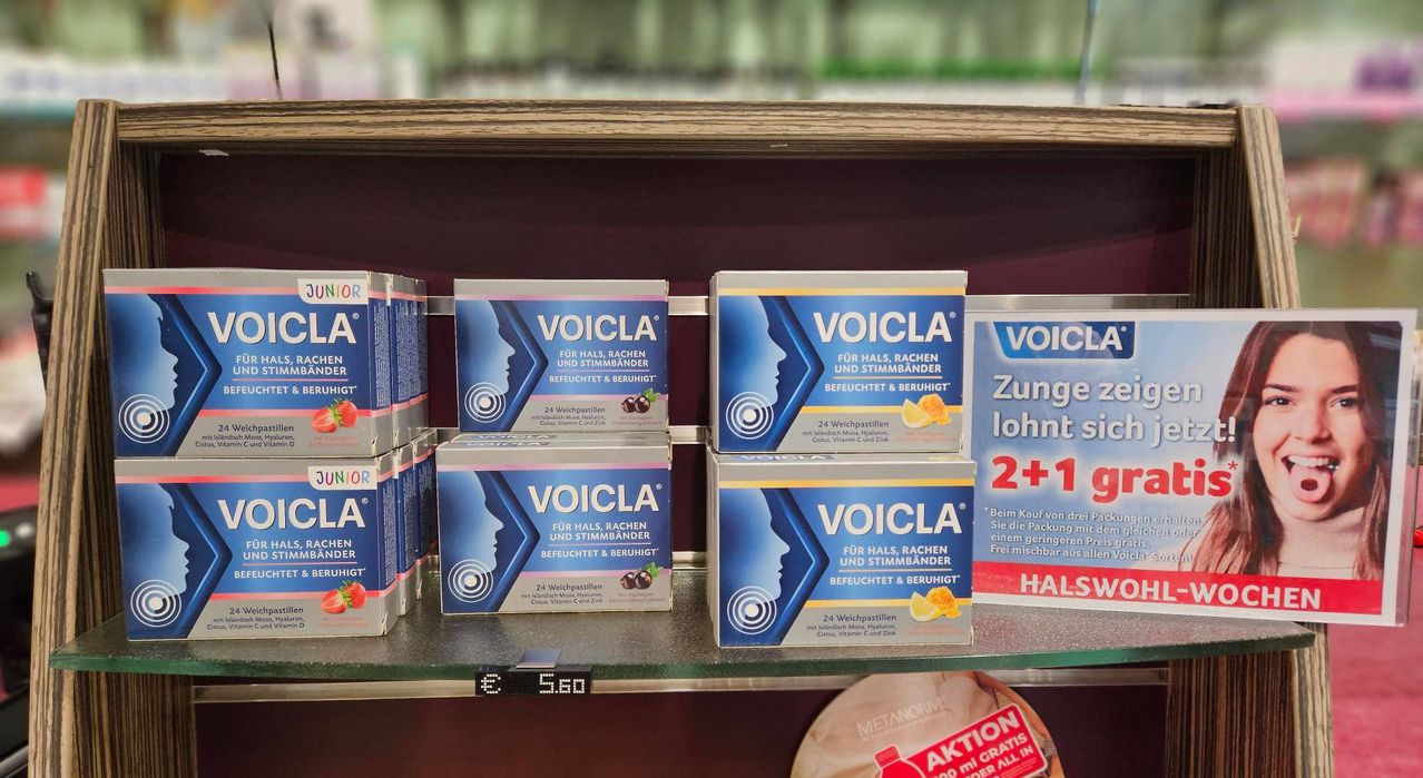 Multiple boxes of Voicla for sore throat and hoarseness sit on a shelf. The boxes have a fruity flavor and contain 24 lozenges.