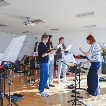 Bild enthält, Furniture, Table, Adult, Female, Person, Woman, Desk, Jeans, Shoe, Glasses