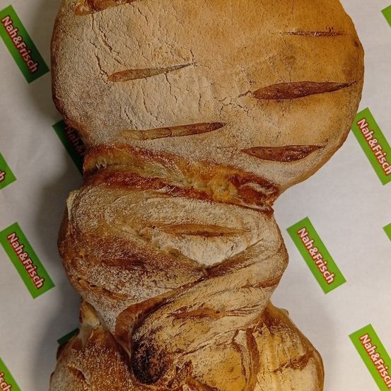 Ein Laib Brot mit goldbrauner Kruste und mehreren Lagen, die aufeinandergestapelt sind, auf einem weißen Hintergrund platziert.