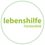 Das Bild zeigt ein Logo für 'lebenshilfe Fürstenfeld', das auf einem weißen Hintergrund mit einem grünen kreisförmigen Rand dargestellt ist.