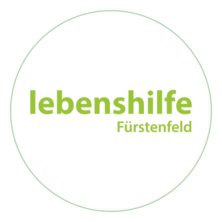 Das Logo von 'Lebenshilfe Furstenfeld' ist in einem kreisförmigen Format mit einem grünen Rand und weißem Hintergrund dargestellt. Der Text ist zentriert und in fetten grünen Buchstaben geschrieben.