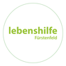 The logo for 'Lebenshilfe Furstenfeld' is displayed in a circular format with a green border and white background. The text is centered and written in bold green letters.