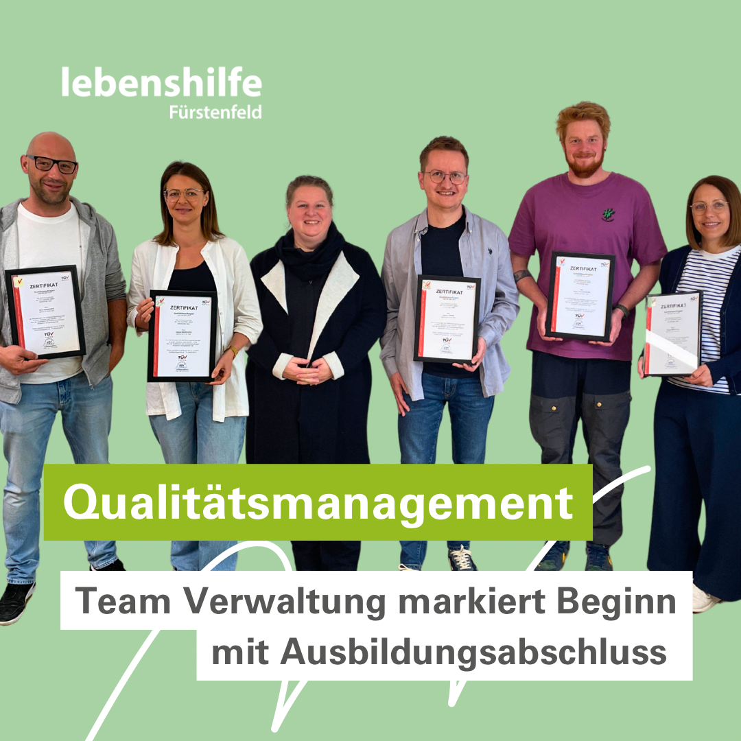 Fünf Personen stehen zusammen und halten Urkunden in den Händen. Drei von ihnen sind Männer und zwei sind Frauen. Sie lächeln für ein Foto.