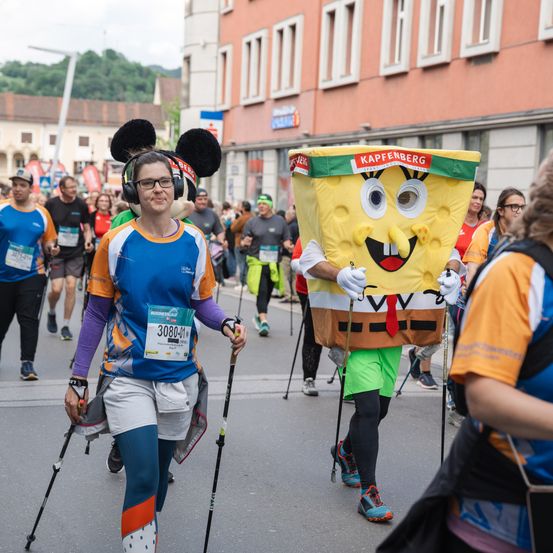 Ein Läufer mit Mickey-Mouse-Kopfband und ein Läufer in Spongebob-Kostüm laufen einen Marathon.
