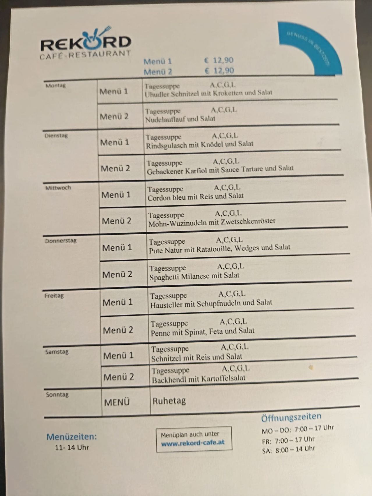 Wöchentliche Speisekarte eines Restaurants. Montag: Menü 1, Uhudler Schnitzel mit Kroketten und Salat; Menü 2, Nudelsuppe. Dienstag bis Sonntag mit verschiedenen Gerichten wie Risotto, Pasta und Salaten. Jedes Gericht kostet 12,90 Euro.