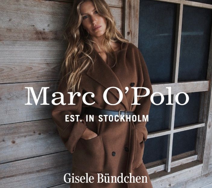 Ein Model in einem braunen Mantel steht neben einer Holzwand mit einem Fenster. Die Worte Marc O'Polo sind über dem Model geschrieben. Der Text Est. In Stockholm steht darunter. Unten steht Gisele Bundchen.