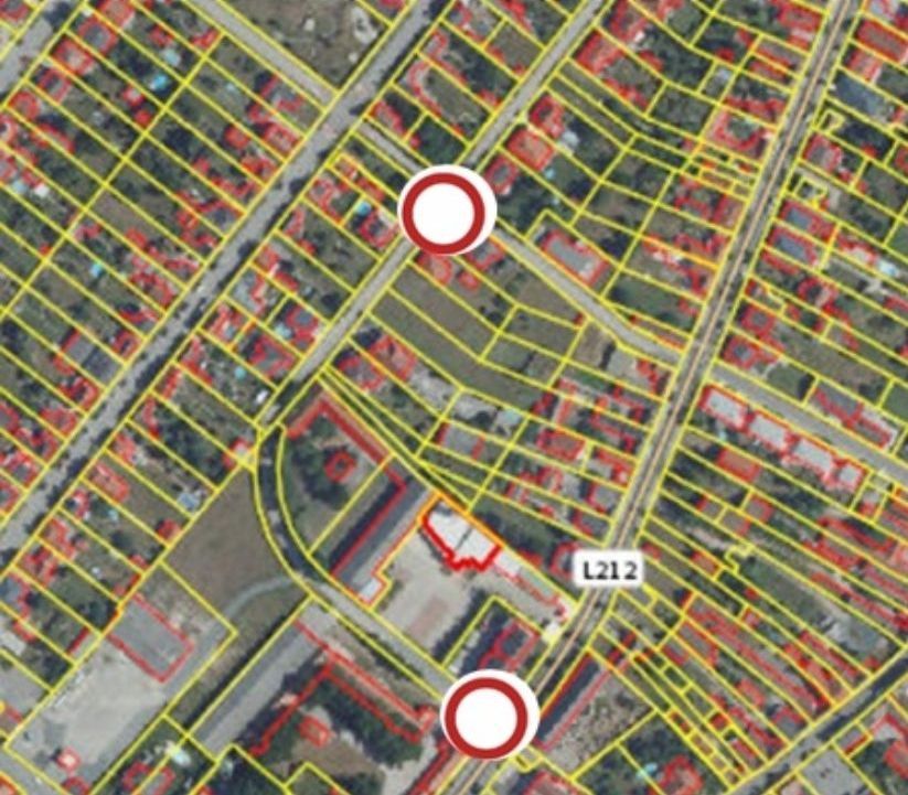 Luftaufnahme eines Vorortgebiets mit mehreren Gebäuden und Straßen. Rote und gelbe Linien heben bestimmte Bereiche hervor, und zwei umkreiste Zonen zeigen Schwerpunktbereiche an.