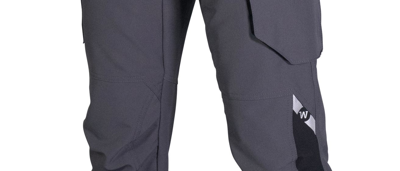 Nahaufnahme einer grauen Cargohose mit Taschen, Reißverschluss und Logo am Bein.