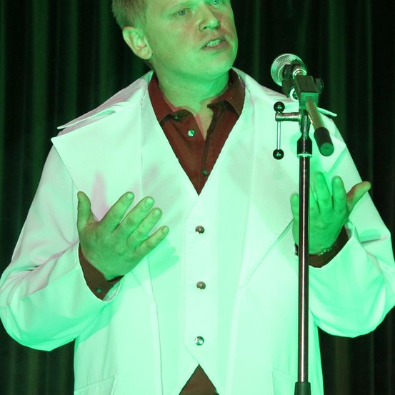 Coat, Microphone, Finger, Person, Solo Performance, Adult, Male, Man, Shirt, Face