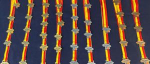 Eine Sammlung roter und gelber Bänder mit Etiketten, die 'Bygd, LM, WA, Indoor' lesen, in Reihen auf einem blauen Hintergrund angeordnet.