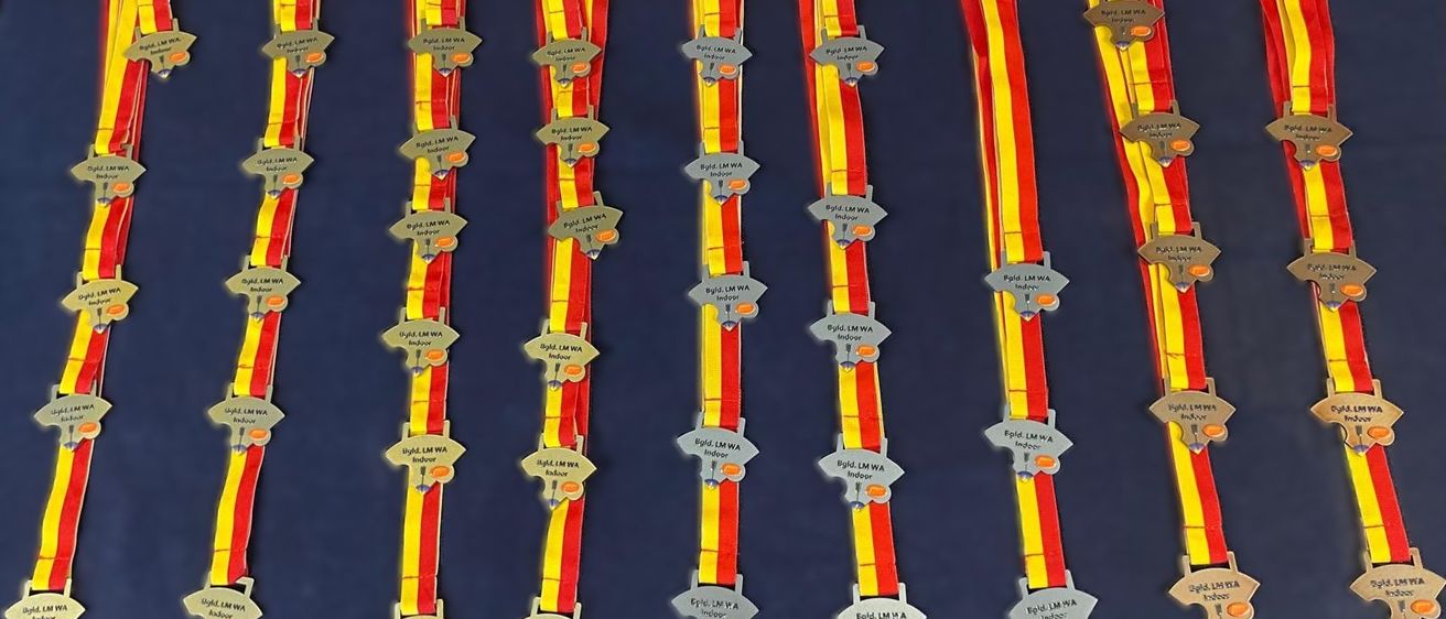 Eine Sammlung roter und gelber Bänder mit Etiketten, die 'Bygd, LM, WA, Indoor' lesen, in Reihen auf einem blauen Hintergrund angeordnet.