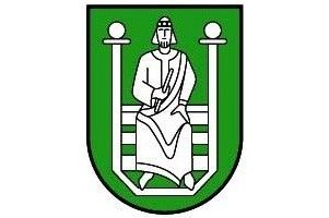 Ein grüner Schild zeigt eine stilisierte Figur eines Mannes, der auf einer Bank mit zwei Pfosten auf jeder Seite sitzt. Der Mann hält ein Buch und scheint zu lesen. Der Schild hat einen spitzen Boden.