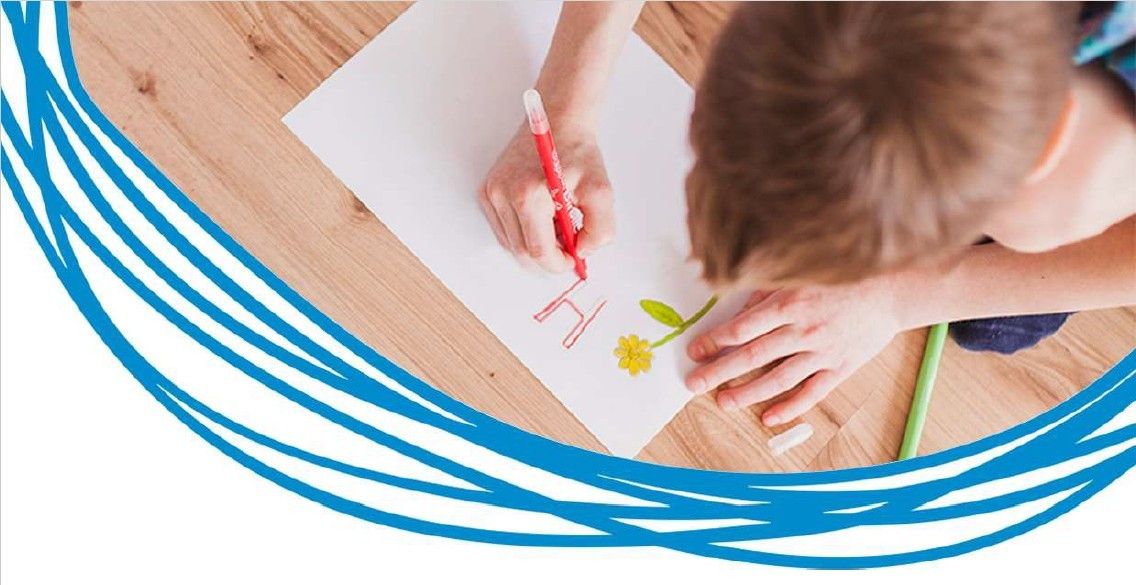 Eine Person zeichnet eine Blume auf ein Stück Papier mit einem roten Marker.