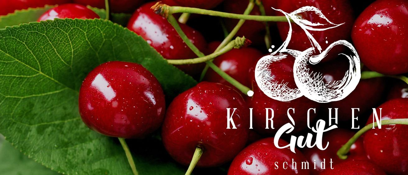 Eine Nahaufnahme einer Gruppe roter Kirschen mit Blättern und Wassertropfen, begleitet von den Buchstaben 'K IR'.
