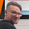 Ein Mann steht neben einer Waschmaschine mit Laptop und bewirbt einen Haushaltsreparaturservice. Der Anzeigentext zeigt Franz Moser, einen Miele-Reparaturspezialisten.