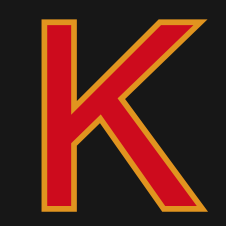 Der Buchstabe 'K' ist in Rot und Gelb auf schwarzem Hintergrund dargestellt. Das Design ist fett und stilisiert.
