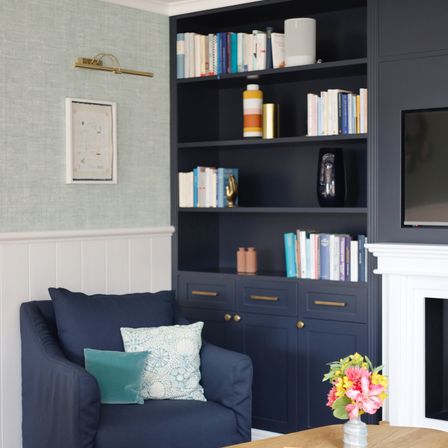 Bild enthält, Interior Design, Furniture, Living Room, Table, Bookcase, Couch, Monitor, Shelf, Home Decor, Flower