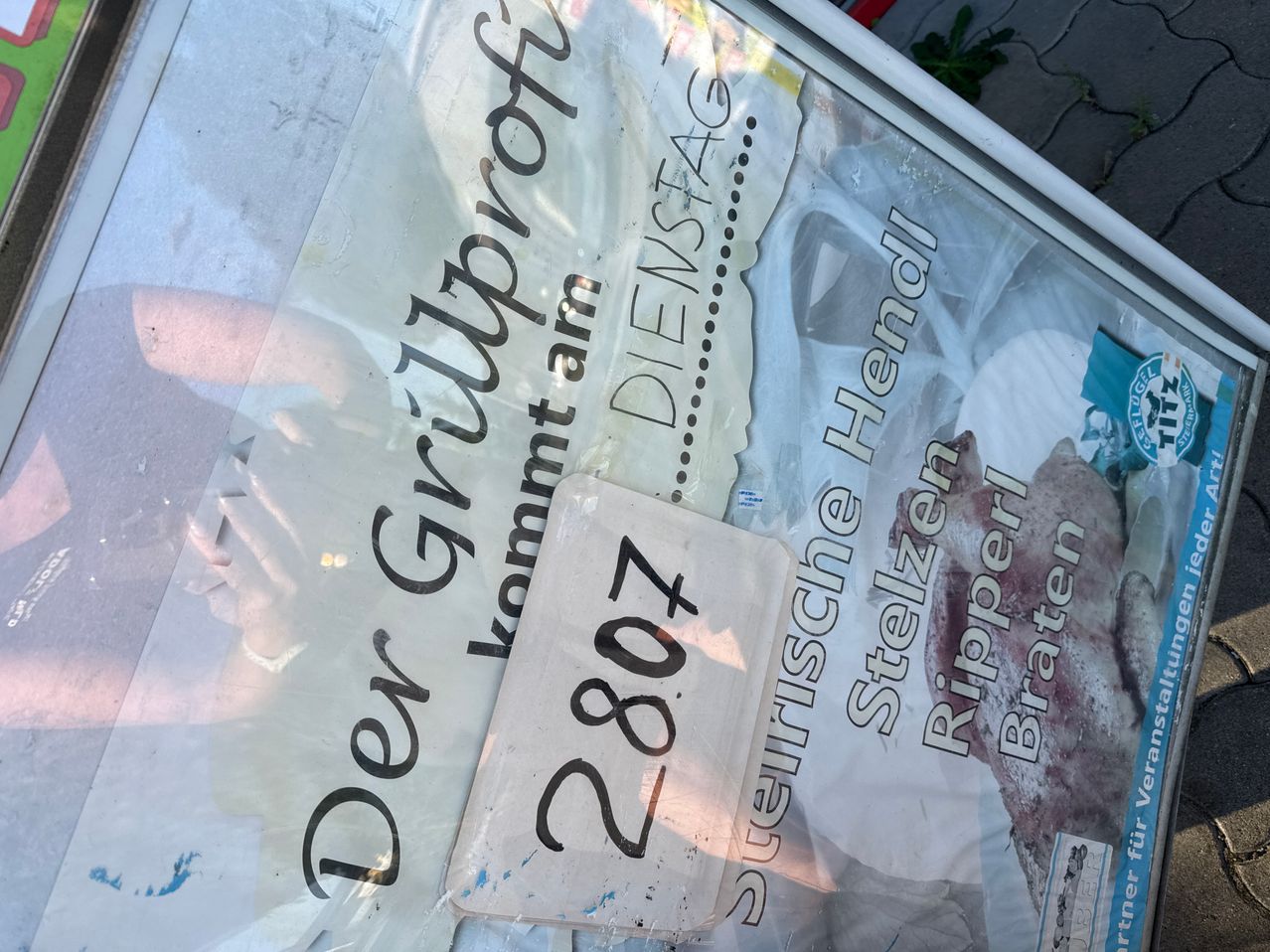 Ein Nahaufnahme eines beschädigten Plastikbogens mit deutschem Text, einschließlich 'Der Gripproof' und 'Kommantarm', und der Nummer '728'. Der Bogen ist durchsichtig mit weißem Hintergrund und scheint Teil einer größeren Ausstellung zu sein.