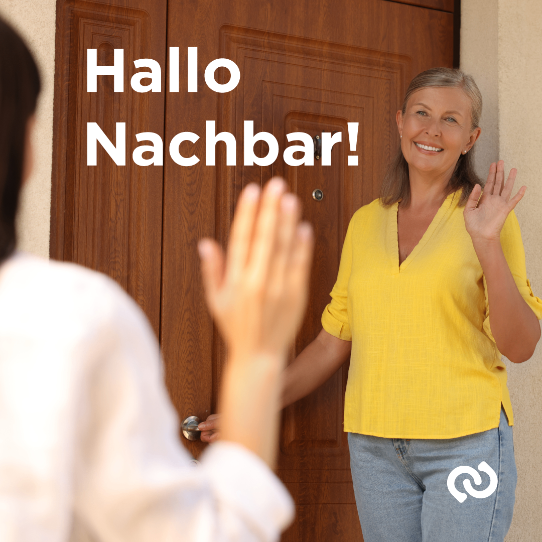 Eine Frau in einem gelben Shirt winkt einer anderen Person an einer Tür zu, auf der in weiß 'Hallo Nachbar!' steht.