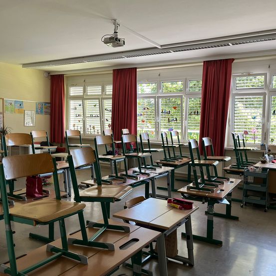 Bild enthält, Furniture, Table, Bag, Handbag, Classroom, Indoors, School, Person, Chair, People