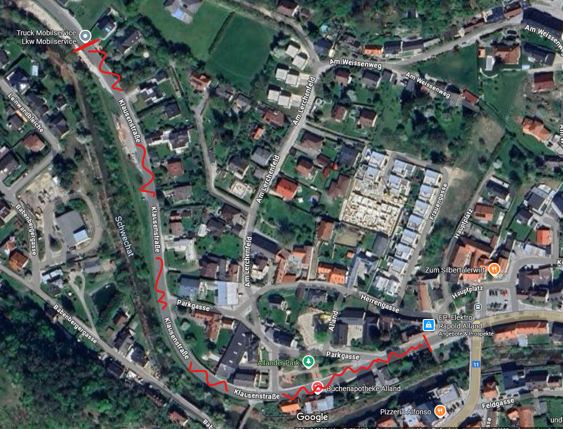 Eine Satellitenkarte zeigt eine kleine Stadt mit mehreren Straßen und Gebäuden. Bemerkenswerte Straßen sind Am Lerchenfeld, Klausenstraße und Parkgasse. Die Karte zeigt eine in Rot markierte Route, die von links oben nach rechts unten führt.