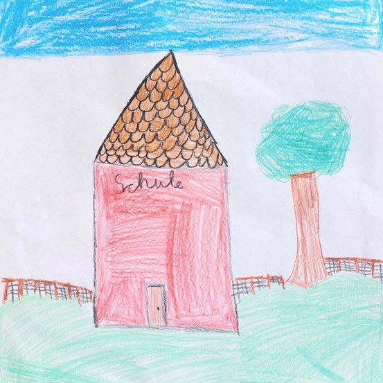 Eine Kinderzeichnung eines Schulgebäudes mit einem geschindelten Dach und dem Wort 'Schule' darauf. Das Gebäude ist von einem Zaun und einem Baum umgeben.