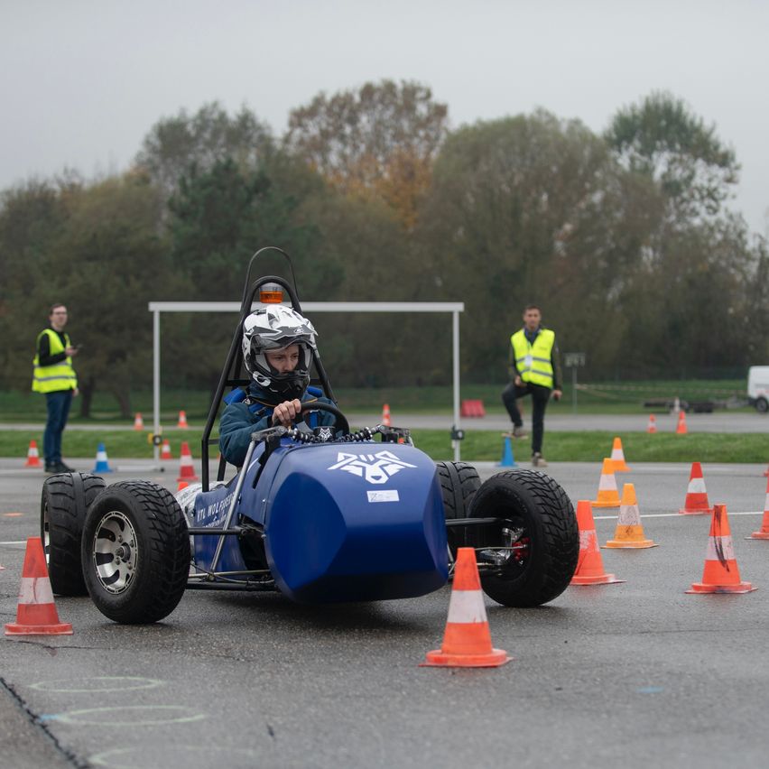Bild enthält, Helmet, Person, Shoe, Spoke, Tire, Hardhat, Car, Tarmac, Wheel, Kart