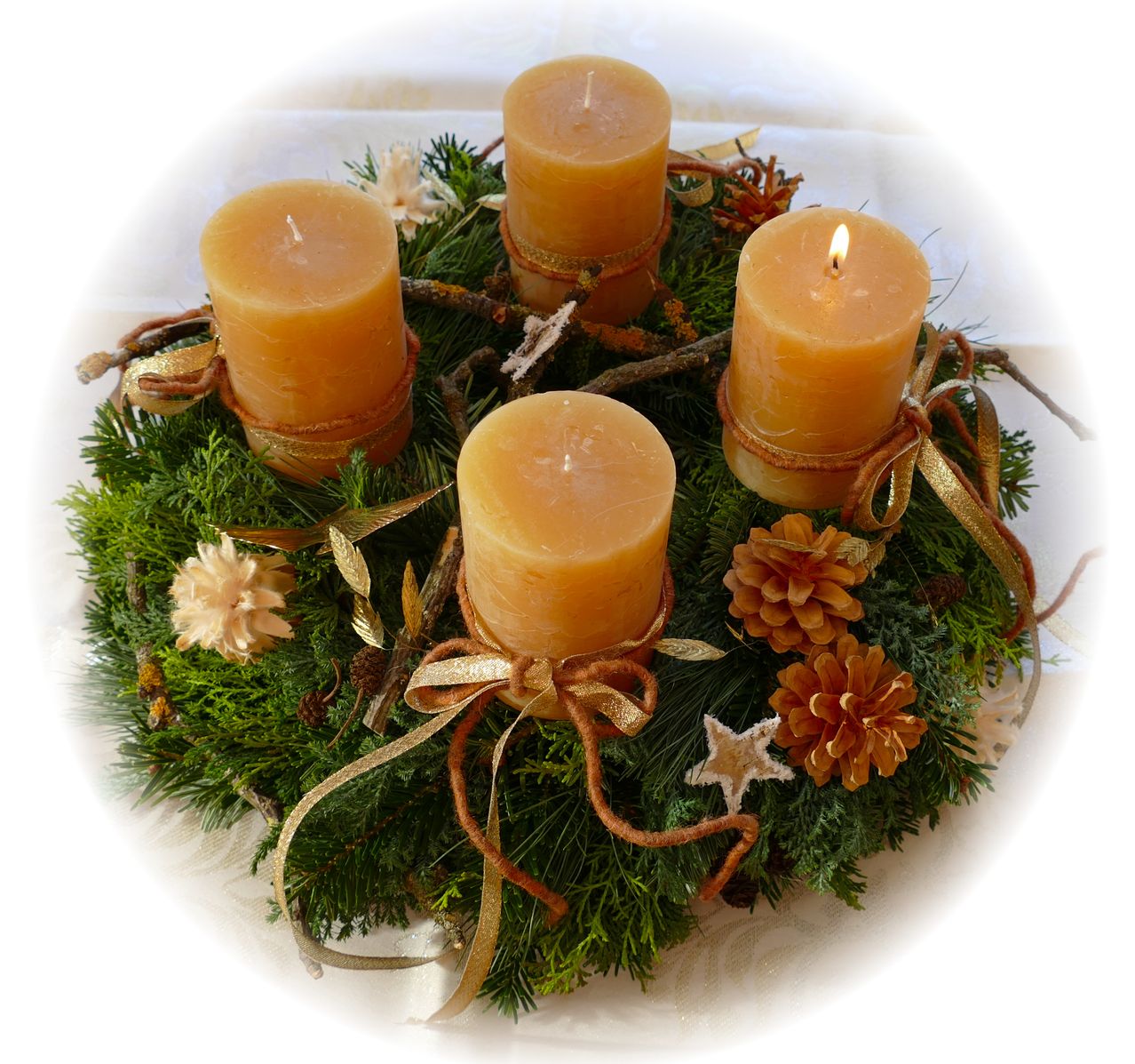 Ein Kranz mit vier gelben Kerzen, umgeben von grünem Moos, Tannenzapfen und kleinen Blumen, alles auf einem weißen Hintergrund.