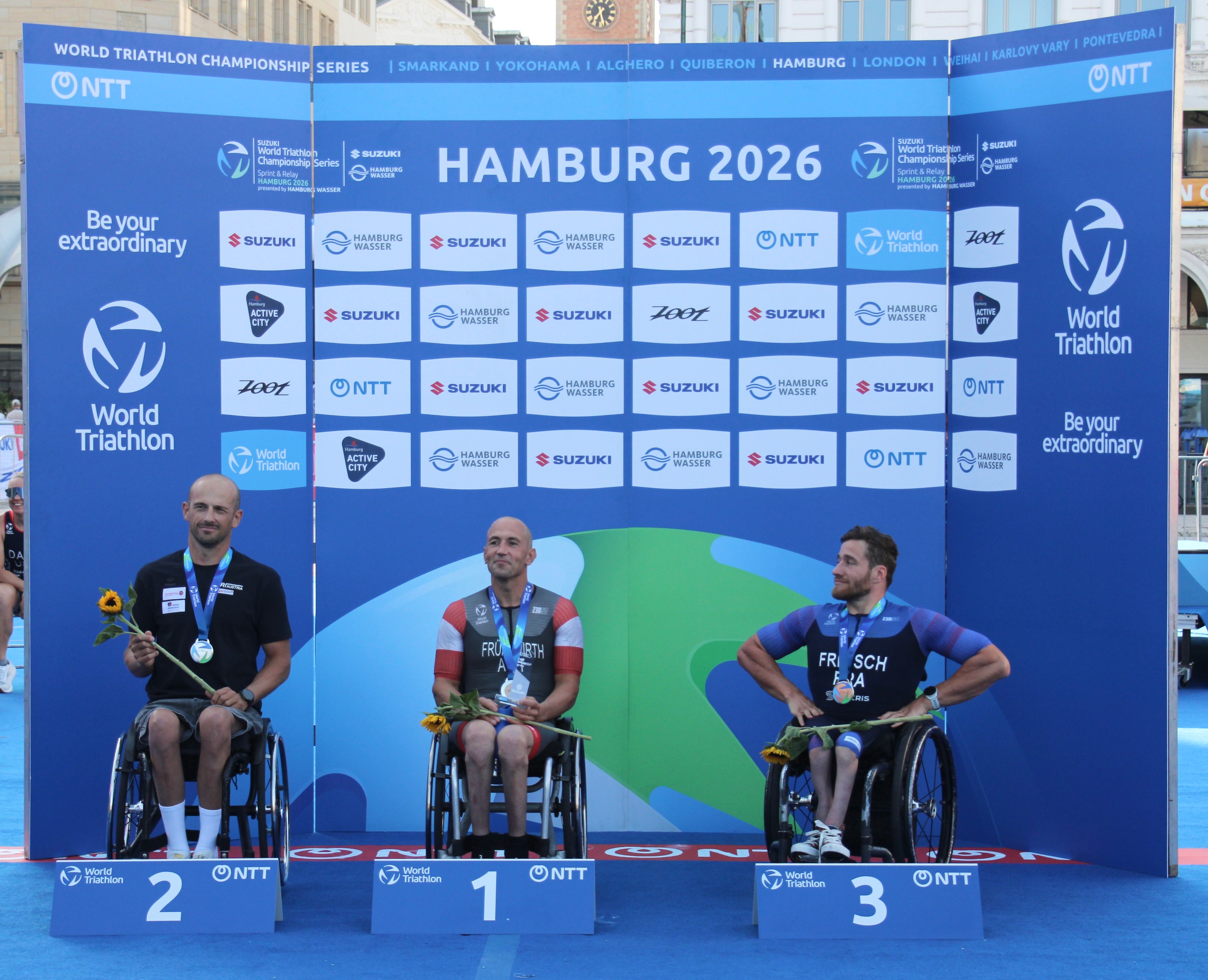 Triathleten mit Medaillen auf Podiumsplätzen in Hamburg 2026.