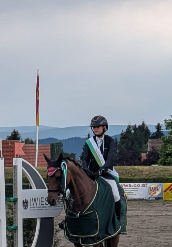 Reiterin mit Pferd bei Reitturnier in Österreich, mit Siegerschärpe