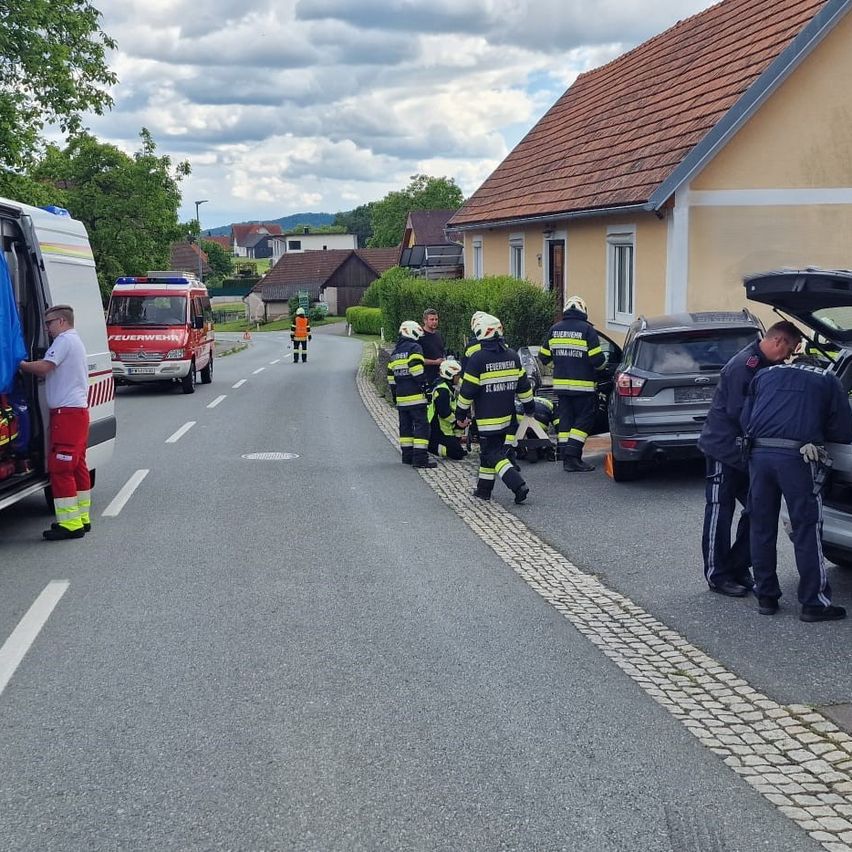 Der Rettungsdienst ist vor Ort. Feuerwehrleute kümmern sich um einen Vorfall mit Kindern am Straßenrand.