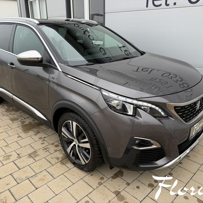 Ein grauer Peugeot SUV steht vor einem Gebäude. Der SUV hat das Kennzeichen 987654321. Das Bild zeigt auch den Text Floris auf dem vorderen Stoßfänger.