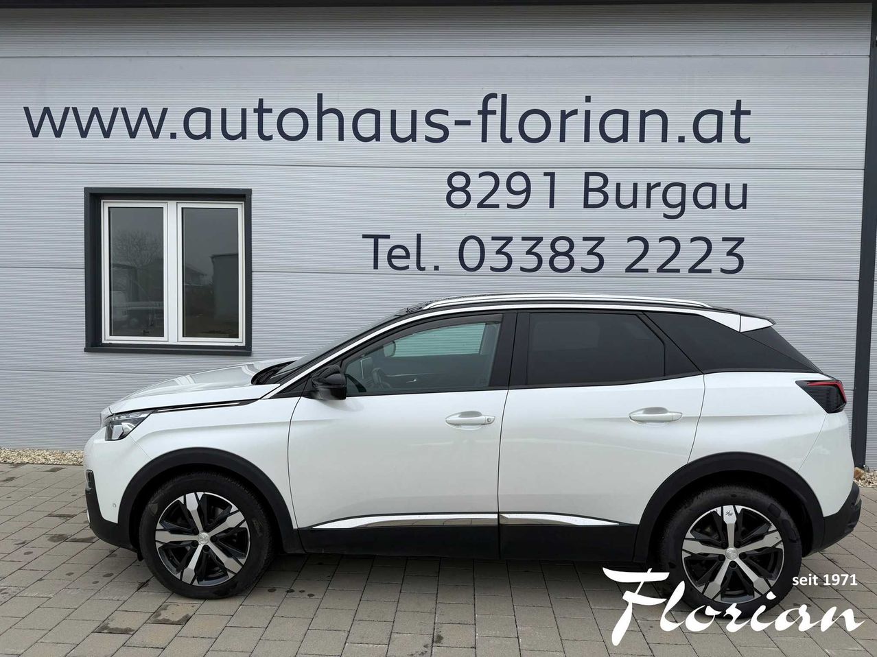 Ein weißer SUV ist vor einem Gebäude mit der Website www.autohaus-florian.at geparkt. Das Gebäude zeigt auch die Adresse 8291 Burgau und die Telefonnummer 03383 2223 an.