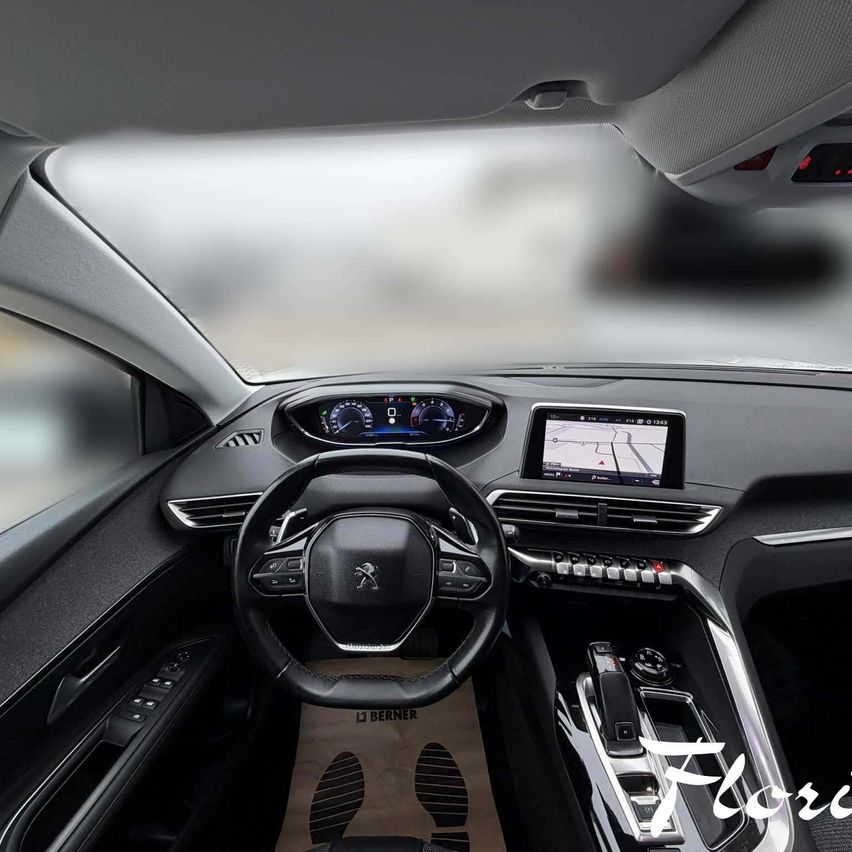 Innenraum eines modernen Peugeot-Autos mit einem eleganten Armaturenbrett, einem digitalen Display, einem Lenkrad und einem Touchscreen.