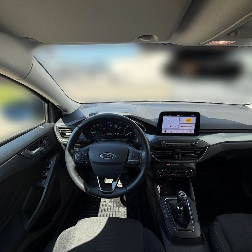 Innenraum eines Ford-Fahrzeugs mit Armaturenbrett, Lenkrad und Touchscreen-Display.
