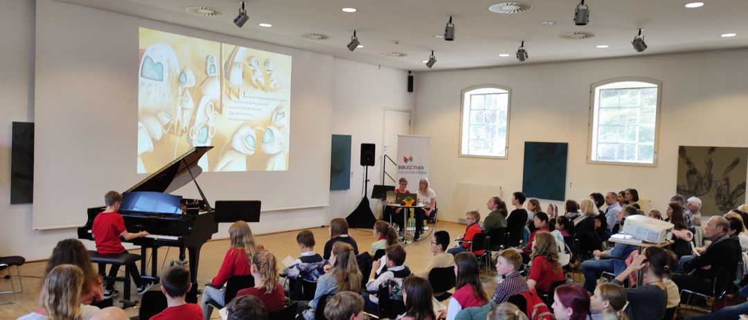 Bild enthält, People, Person, Musical Instrument, Piano, Speaker, Crowd, Classroom, Indoors, Face, Shoe